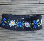 Must villane käsitsi tikitud vöö.